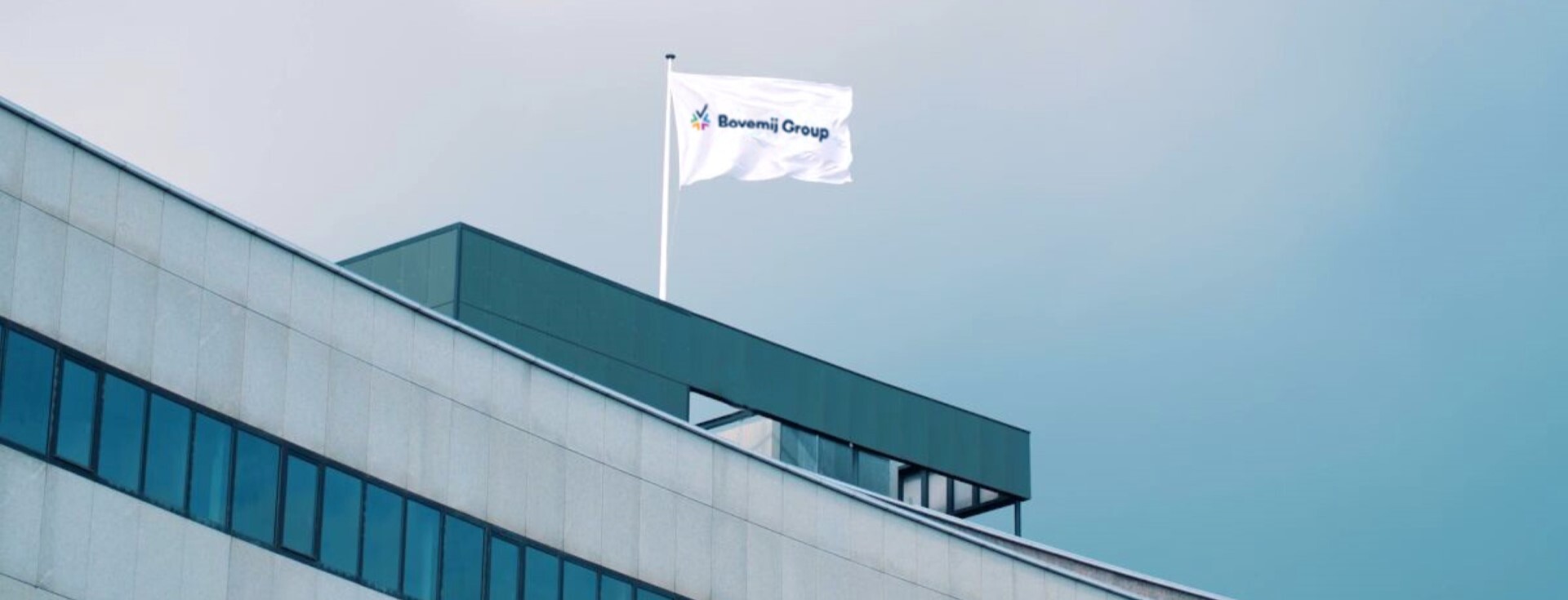 Kantoorpand van Bovemij Group met wapperende vlag op het dak.