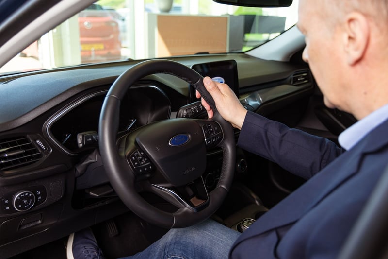 Bestuurder bij auto in showroom